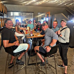 a group of people at a brewery sitting down smiling