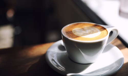 a latte in a coffee cup on top of a saucer